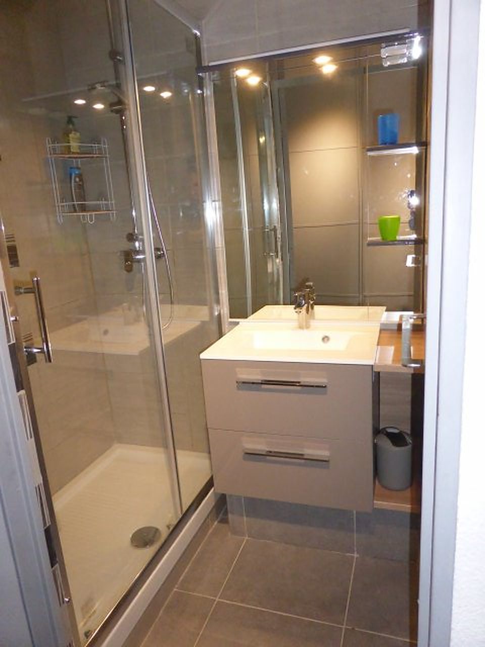Salle d’eau avec douche à paroi vitrée et meuble vasque